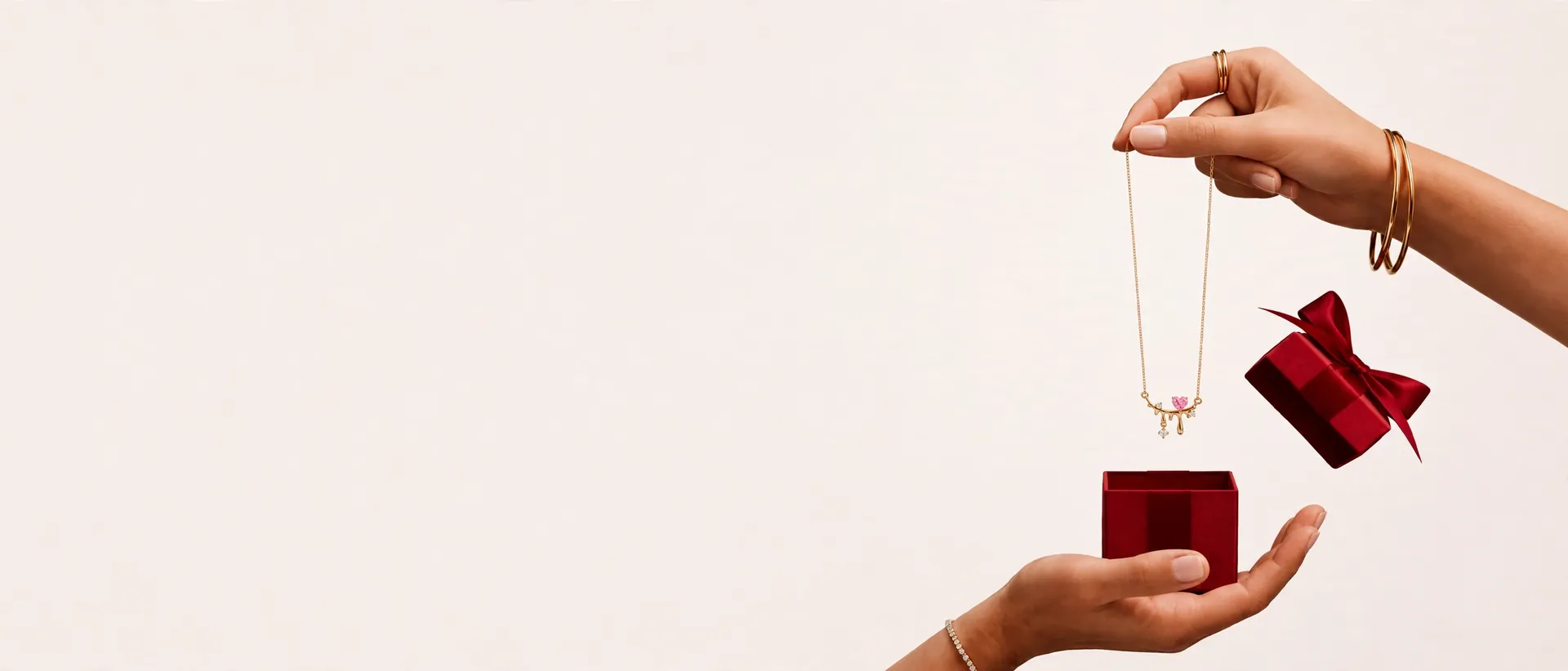 Hands holding Anisan necklace above red gift box